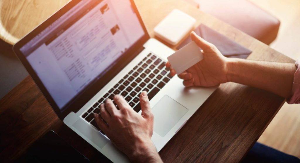 person-paying-bill-on-laptop-holding-credit-card_shutterstock_268450025-e1566491316880.jpg