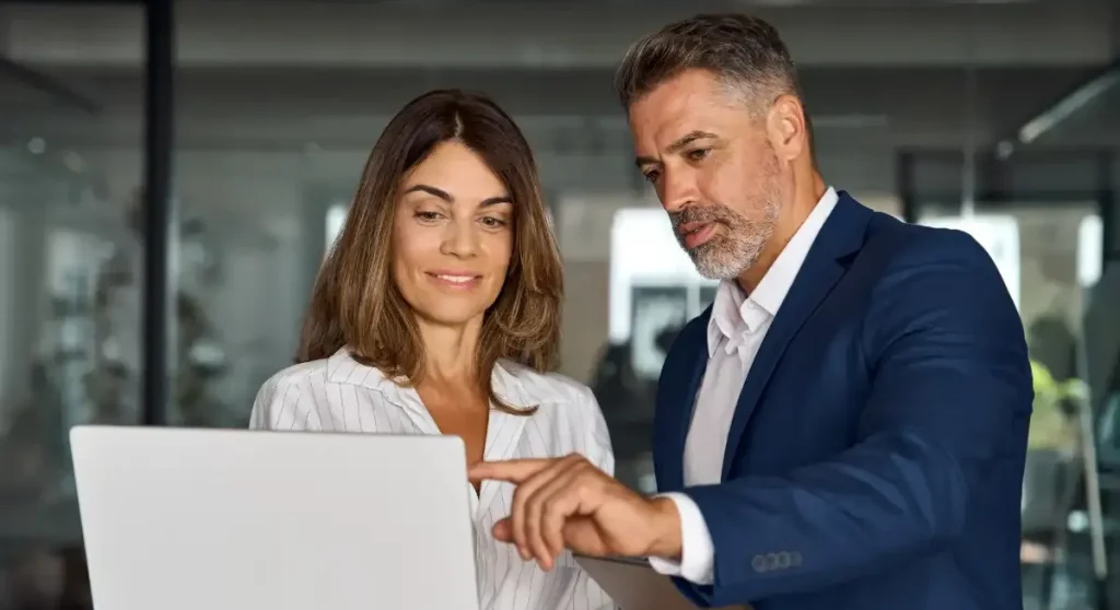 man and women looking at computer in office