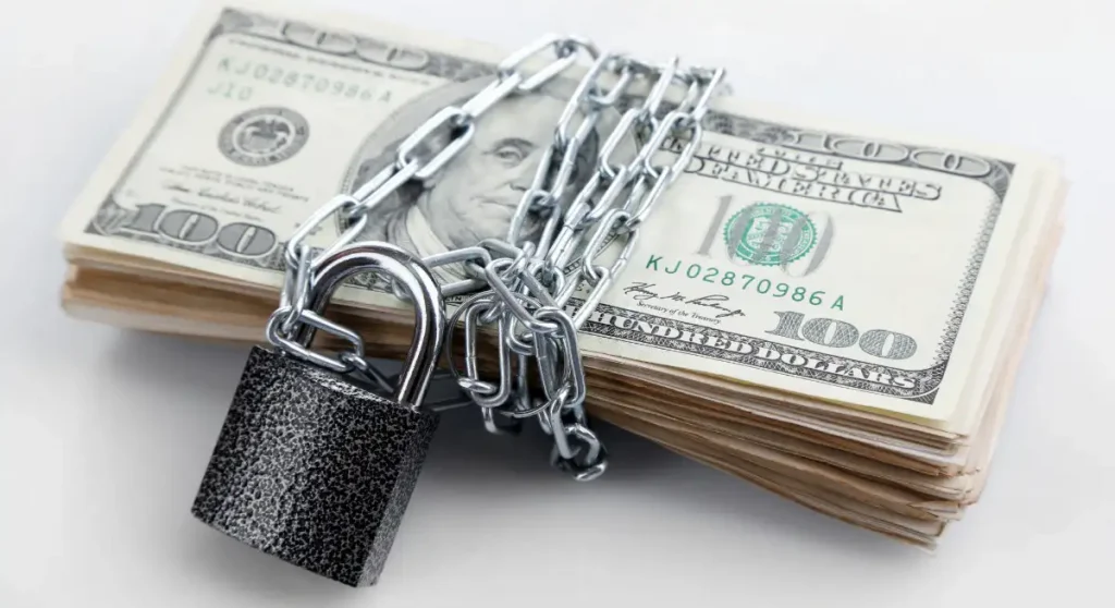 stack of money wrapped with lock and chain