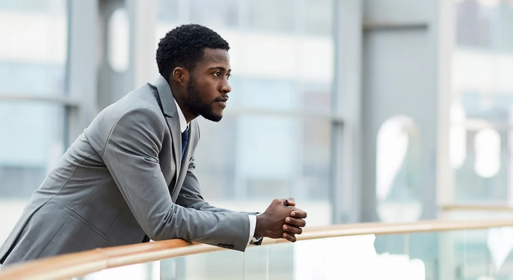 Thoughtful businessman leaning on railing
