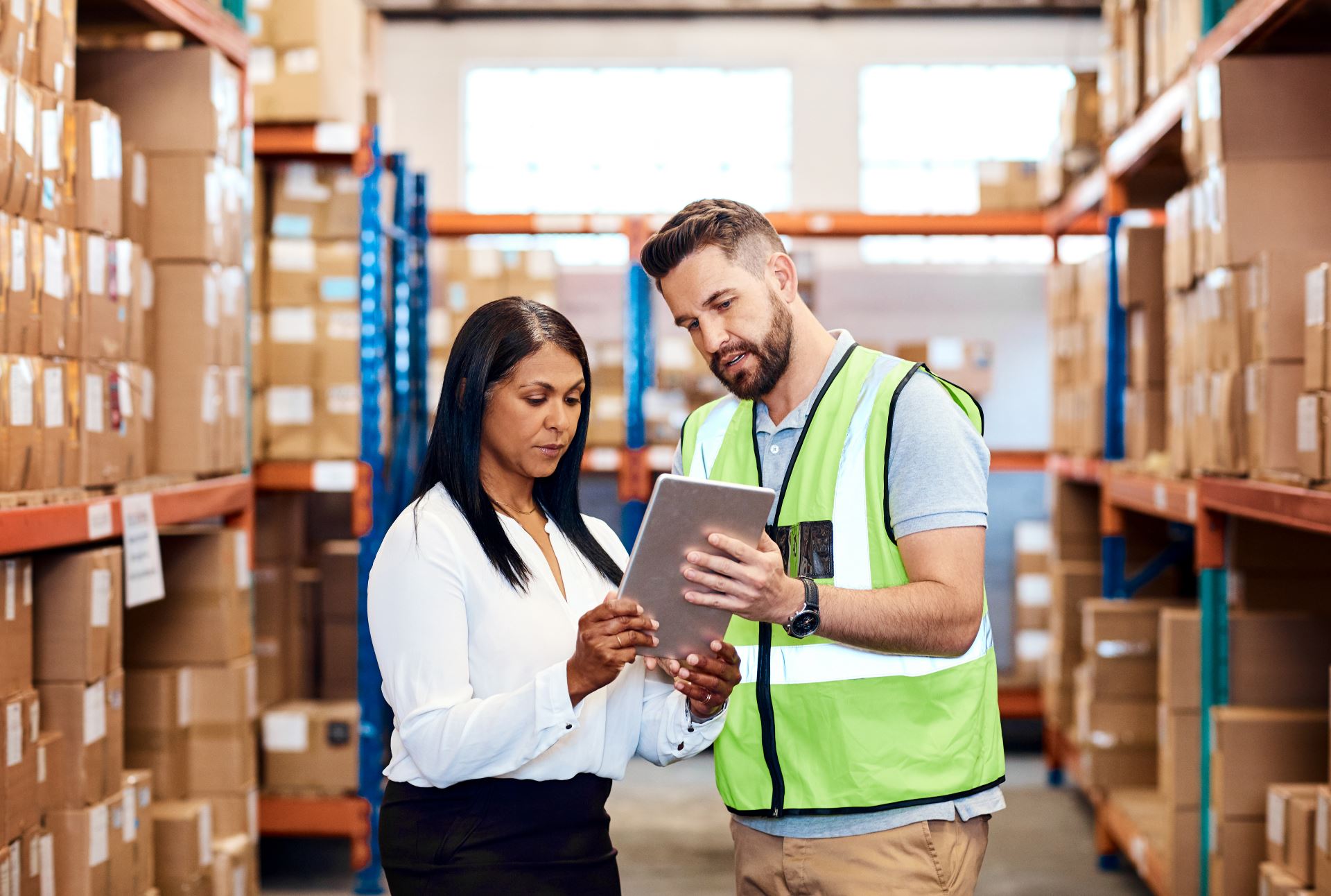 Supply chain: woman and man in a warehouse looking at a tablet