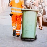 Mitarbeiter eines Unternehmens für umwelttechnische Leistungen mit Mülltonne